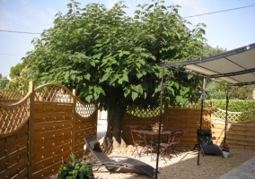 terrasse à l'entrée clôturée disposant à l'intérieur de deux transats pour la détente