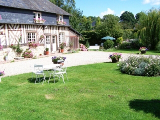 vue du gîte dès l'ample terrasse entourée par la fôret et décorée de fleurs disposant
